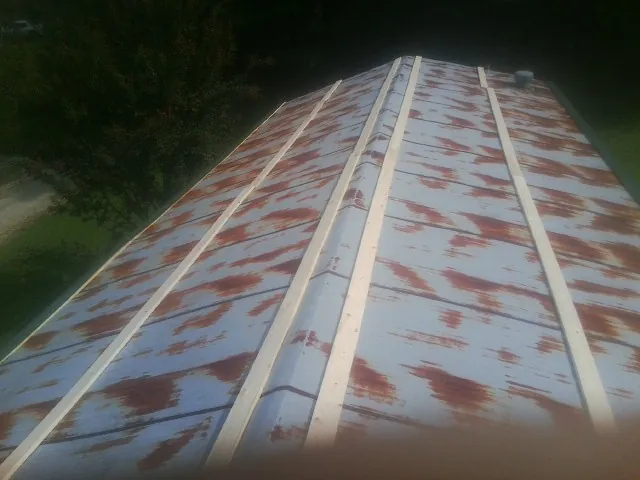 Rusted metal roof panels with new wood purlins before replacement — Storm Damage Roof Repair in Patoka by Roofing Brothers