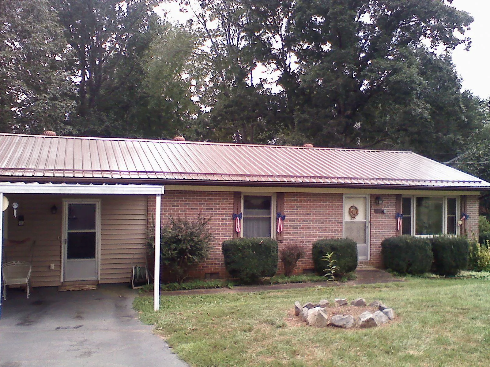 Bronze metal roof and carport on a brick ranch home — Roof Repair work by our crew in Patoka